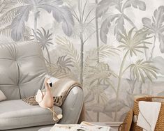 a living room with a couch, chair and wallpaper that has palm trees on it