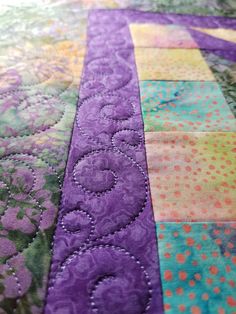 a close up view of a quilted table runner with circles and flowers on it