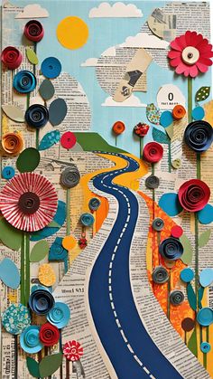 an art project made out of books with paper flowers and buttons on the road that runs through it