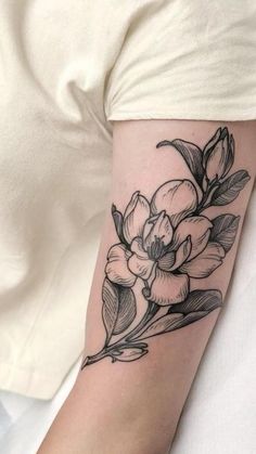 a black and white flower tattoo on the arm