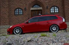 a red car parked in front of a brick building