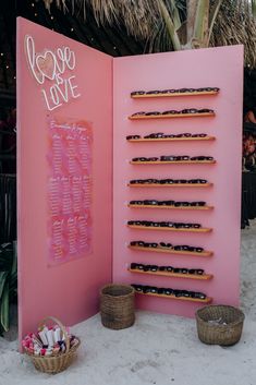 a pink sign with donuts in front of it and baskets on the ground next to it