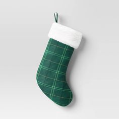 a green christmas stocking hanging from the side with a white top and plaid pattern