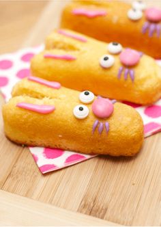 three donuts with faces on them sitting on a table