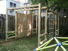 an outdoor play area made out of wood and plastic pipes, in the back yard