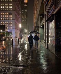 two people walking down the street in the rain with umbrellas