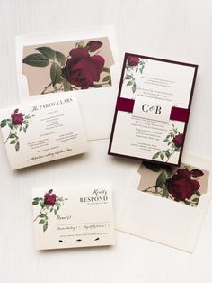 the wedding stationery is laid out on top of each other, with burgundy roses