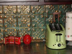 a green toaster sitting on top of a kitchen counter next to a red cup