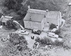 an old black and white photo of cars parked in front of a house