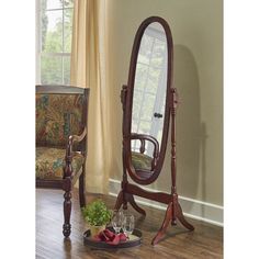 a mirror sitting on top of a wooden floor next to a chair and table with wine glasses