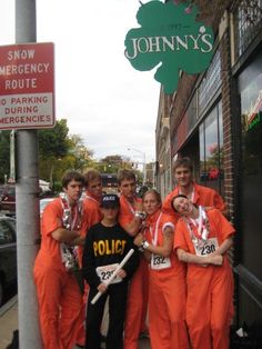 a group of people in orange jumpsuits posing for a photo on the street