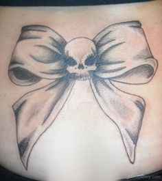 a woman's stomach with a skull and bow tattoo