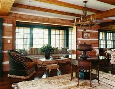 a living room filled with furniture and wooden walls