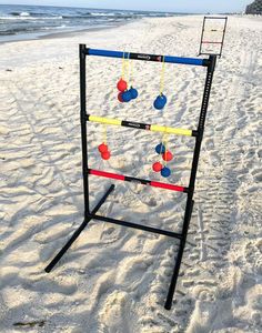 an outdoor game set up on the beach with balls and chains hanging from it's sides