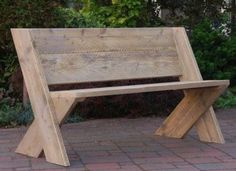 a wooden bench sitting on top of a brick walkway