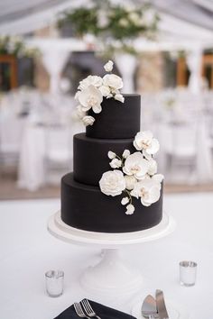 a black and white wedding cake with flowers on top