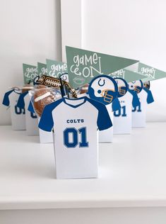 paper football jerseys are on display in front of other sports themed items, including cookies and candy