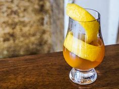 a glass filled with liquid sitting on top of a wooden table