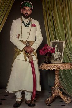 a man dressed in white standing next to a table