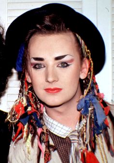 two people with weird hair and makeup are posing for a photo in front of a white door