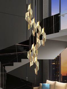 a modern chandelier hanging from the ceiling in a living room next to a couch