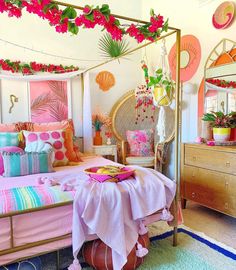 a bedroom decorated in pink, orange and green colors with flowers on the ceiling above the bed