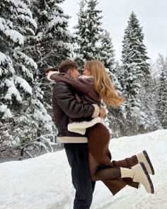 a man and woman are hugging in the snow