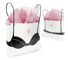 two white bags with pink tissue paper in them