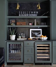 a kitchen with green cabinets and black counter tops