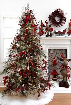 a decorated christmas tree in front of a fireplace