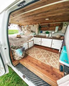 the interior of a camper van with wood flooring and storage area in the back