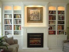 a living room filled with furniture and a fire place in the middle of bookshelves