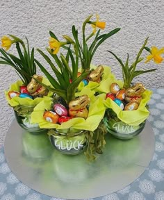 an arrangement of flowers and chocolate eggs on a table