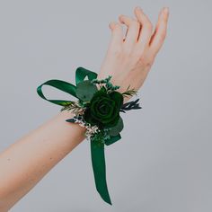 a woman's hand with a green wrist corsage