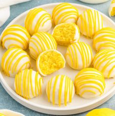 some yellow and white striped cookies on a plate with lemons in the back ground