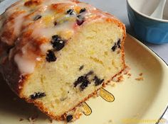 a blueberry bundt cake on a plate next to a cup