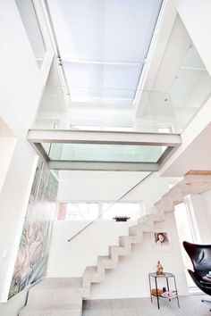 an open staircase leading up to the second floor in a modern home with white walls and glass balconies