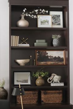 a bookshelf filled with pictures and vases