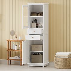 a white bathroom cabinet with drawers and baskets on the floor next to a basket filled with toiletries