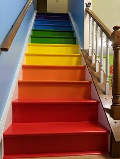 the stairs are painted bright colors with wooden handrails