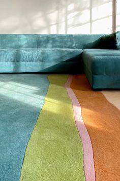 a blue couch sitting on top of a colorful rug