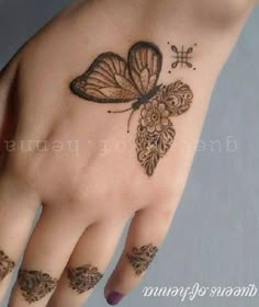 a woman's hand with a butterfly tattoo on it