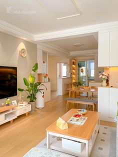 a living room filled with furniture and a flat screen tv mounted on a wall above a wooden coffee table