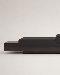 a black speaker sitting on top of a wooden shelf next to a white wall and floor