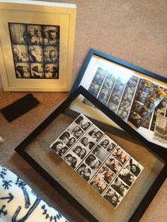 two framed photographs and one with pictures on it sitting on the floor next to a pillow