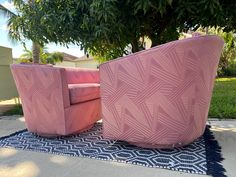 two pink chairs sitting next to each other on a rug