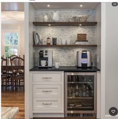 a kitchen with white cabinets and black counter tops, an oven and coffee maker in the corner