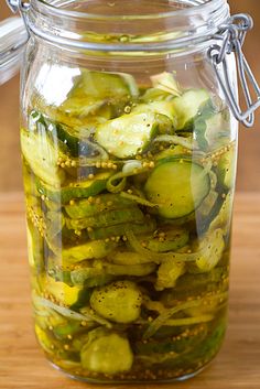 pickled cucumbers in a glass jar on a wooden table