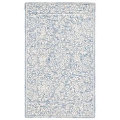 a blue and white rug with an intricate design on the bottom, in front of a white background