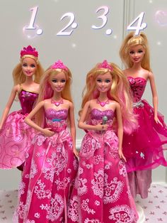 three barbie dolls standing next to each other in front of a wall with numbers on it